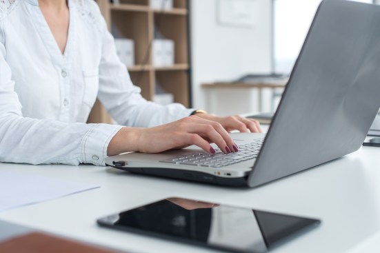 Working with laptop woman writing a blog. Female hands on