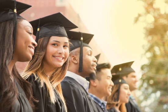 Latin descent female college student graduation on campus.