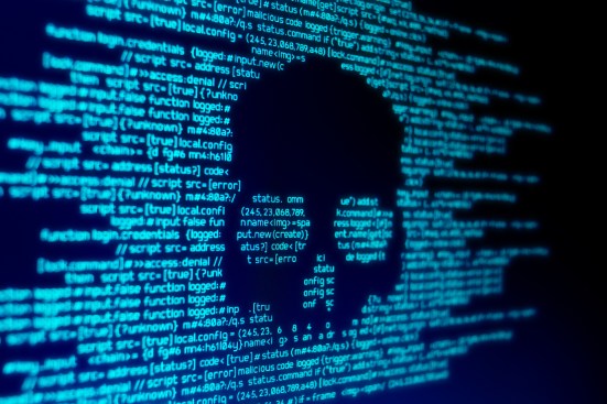 Computer code on screen with a skull representing hackers attacking the education system
