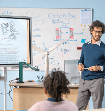 A male teacher using a document camera to magnify classroom lesson materials.
