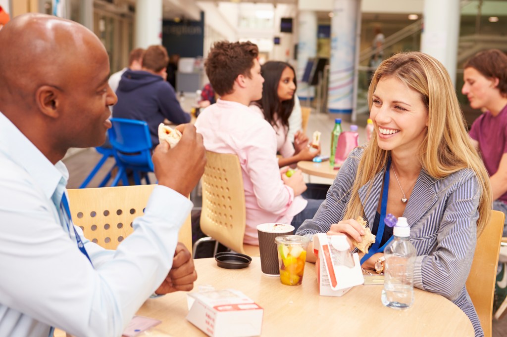Teachers practicing a language together at lunch.