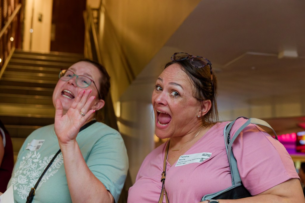 Two ladies laughing and singing at an industry event