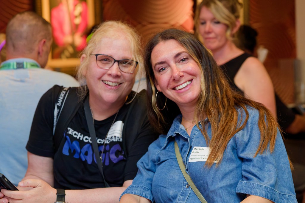 Two women smiling for a photo at a networking event