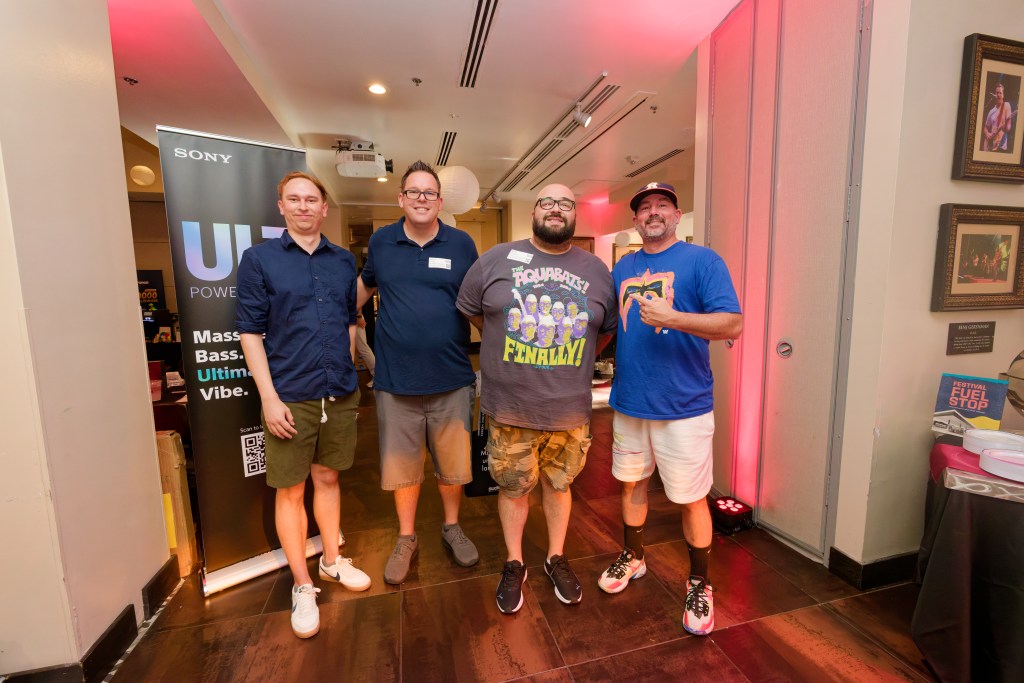 Group of 4 men standing for a picture at a networking evnet