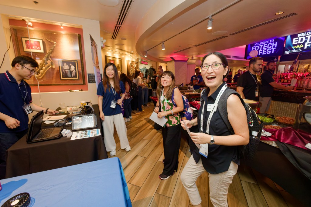 Ladies interacting and laughing with a vendor at an industry event