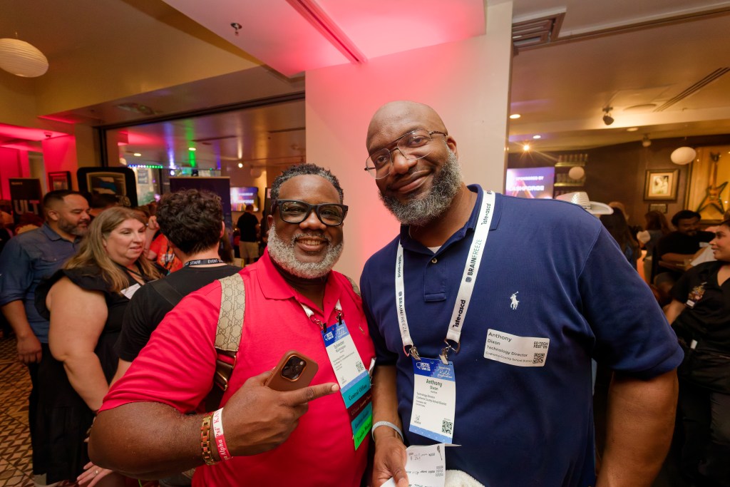 Two men posing for photo and smiling at industry event